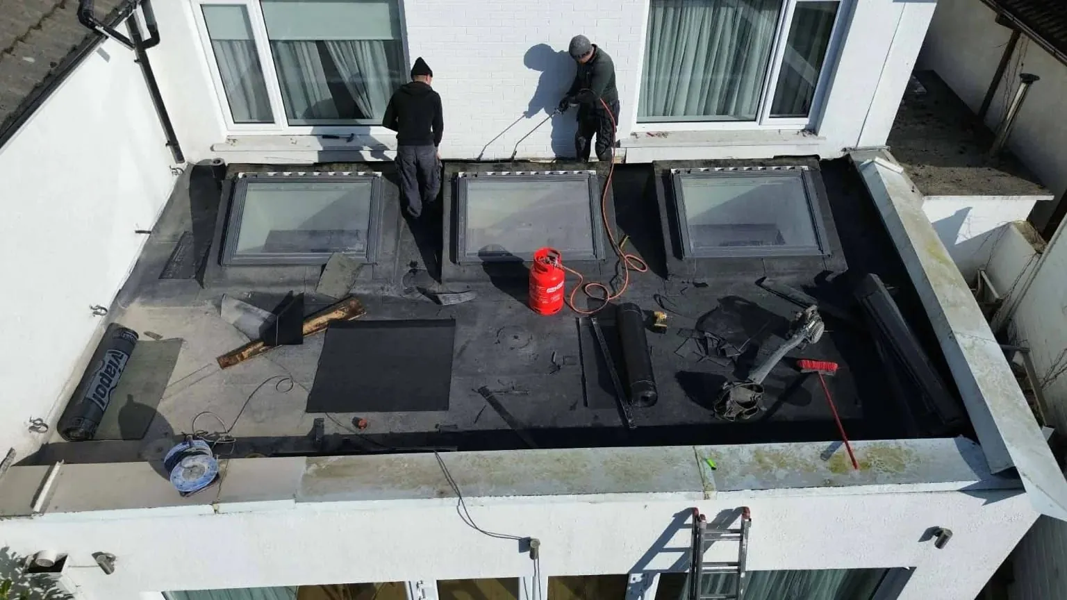 Roofers laying torch-on felt