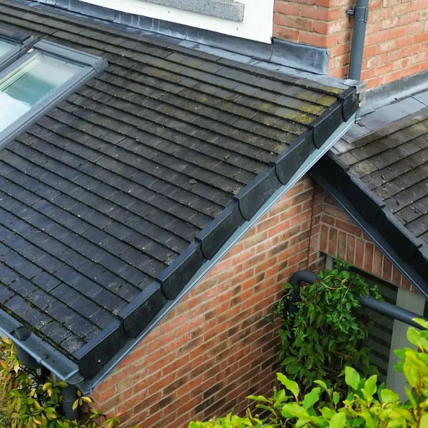 Concrete tiled roof meeting a brick gable