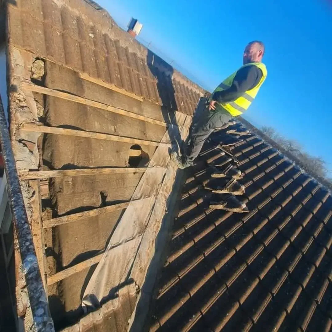 Roofer stripping an old tiled roof