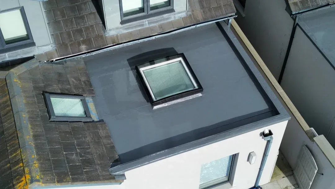 Flat roof with a rooflight beside a slate roof